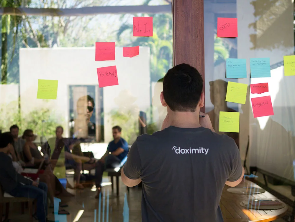 Doximity engineers and designers working with stickies on wall